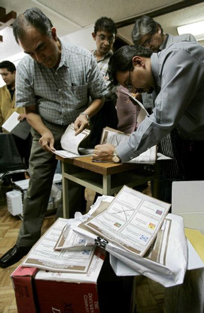 
Election officials hand count votes Wednesday at a branch of the National Electoral Institute in Mexico City as party observers look on. Similar scenes took place in 300 electoral districts nationwide. 
 (Associated Press / The Spokesman-Review)