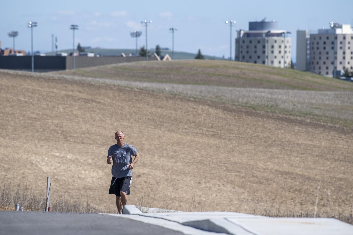 Dave Cook, the longtime Sports Information Director at Eastern Washington University, takes an unpaved back road near EWU on his daily three-mile runs Tuesday, April 21, 2020. He’s determined to run at least three miles every day. (Jesse Tinsley / The Spokesman-Review)