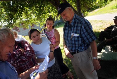 Beth Mort, of The Lands Council, talks with Timofey Fedchun, left, Peter Shelestun, right, and other members of the Russian community about the dangers of eating fish from the Spokane River at the Peaceful Valley Community Center.   (Rajah Bose / The Spokesman-Review)