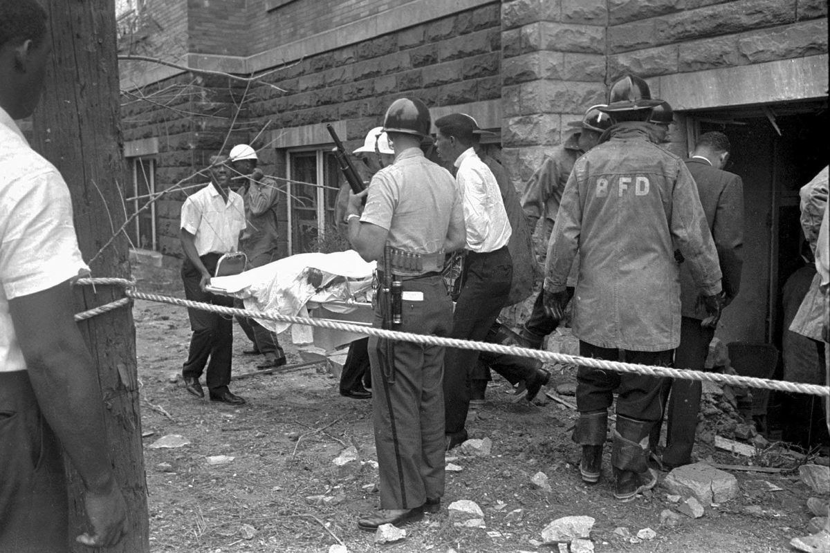 FILE - Firefighters and ambulance attendants remove a covered body from the 16th Street Baptist Church in Birmingham, Ala., after a deadly explosion detonated by members of the Ku Klux Klan during services on Sept. 15, 1963. Threats against Black institutions are deeply rooted in U.S. history and leaders say the history of violence against people of color should be passed on to new generations so the lessons of the past can be applied to the present. (STR)