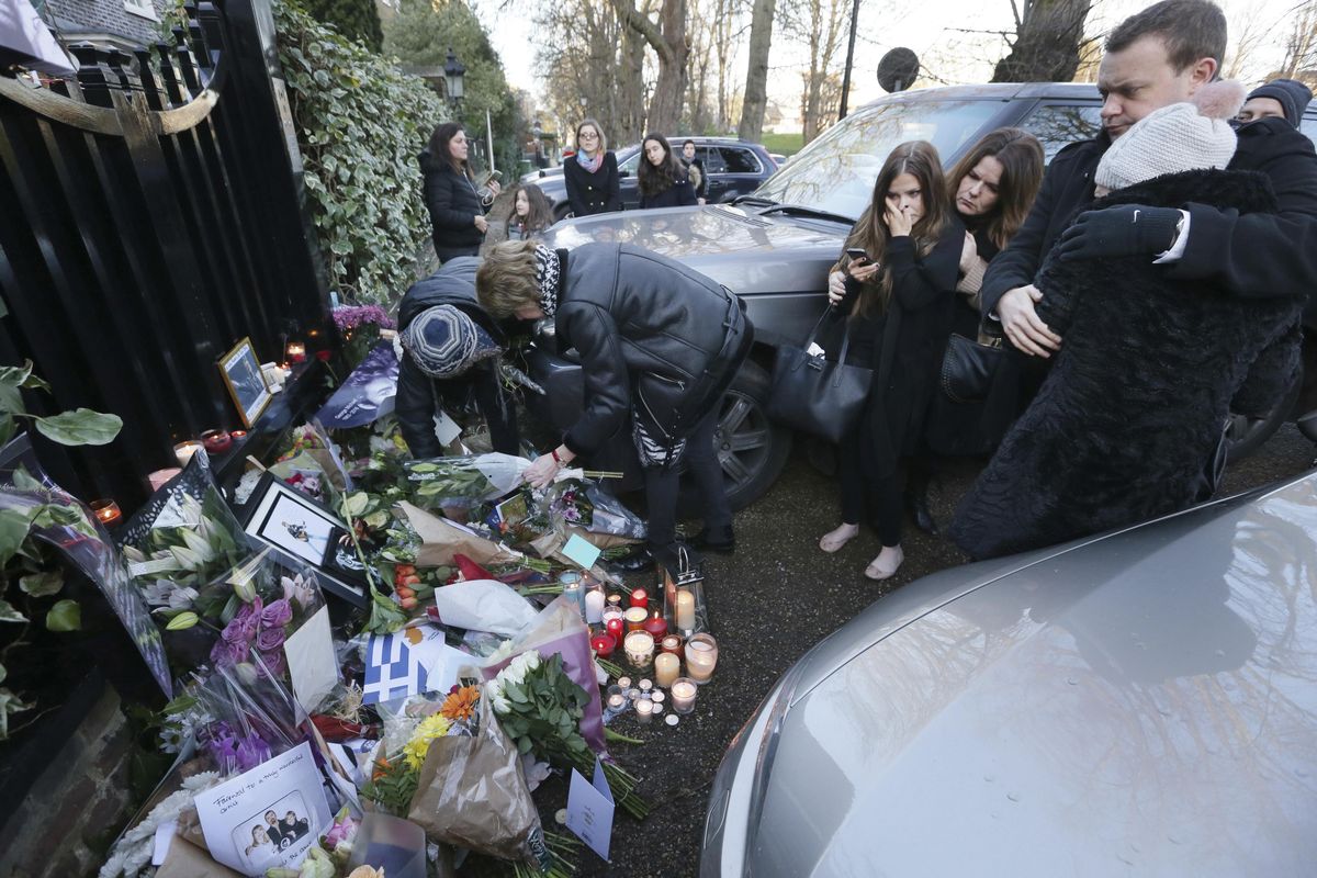 People view tributes left outside the home of British musician George Michael in London on Monday, Dec. 26, 2016. (Tim Ireland / Associated Press)