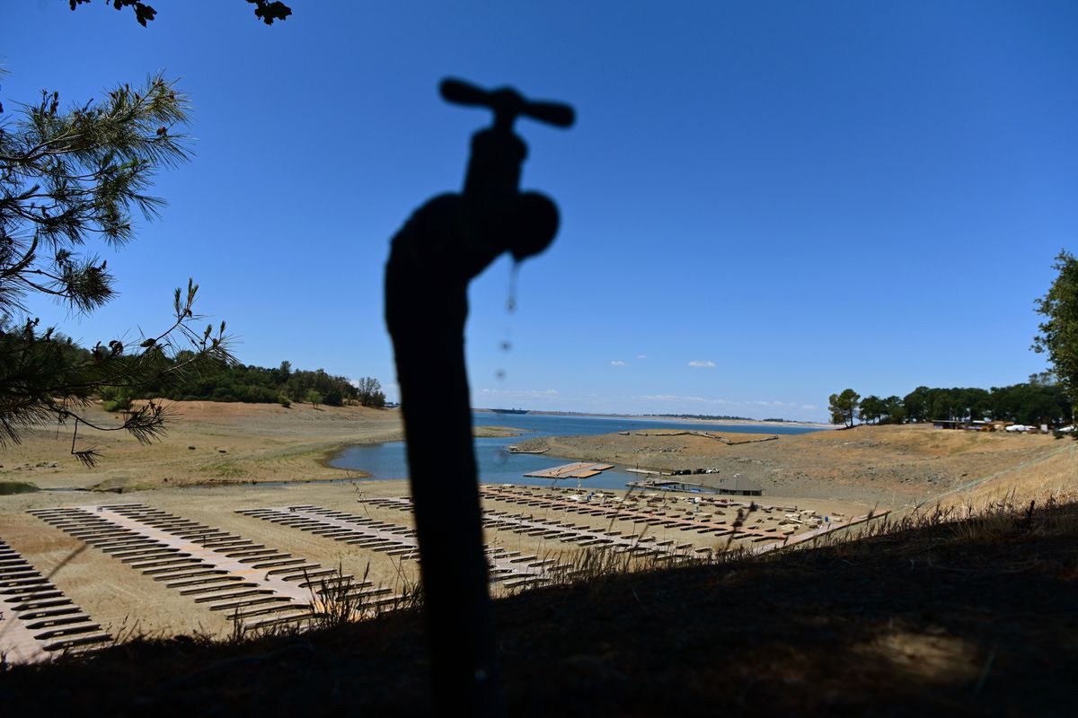 FILE - Water drips from a faucet near boat docks sitting on dry land at the Browns Ravine Cove area of drought-stricken Folsom Lake in Folsom, Calif., on May 22, 2022. The American West