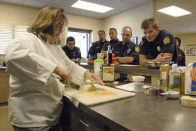 
Chef Susan Kalin with NuCulinary of Seattle demonstrates how to use a knife to properly dice an onion during a training session for the Spokane Valley Fire Department Wednesday. Employees received hands-on training intended to educate them about  purchasing, preparing and cooking healthy meals.
 (Photos by J. BART RAYNIAK / The Spokesman-Review)