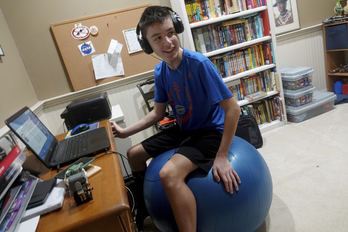 FILE - In this Aug. 31, 2020, file photo, Andrew Burstein, 13, logs onto 8th grade class with Don Estridge High Tech Middle School from his home in Delray Beach, Fla., during the first day back for Palm Beach County Schools. Burstein said it took about an hour to log into school but after the delay he had no issues.  (Joe Cavaretta)