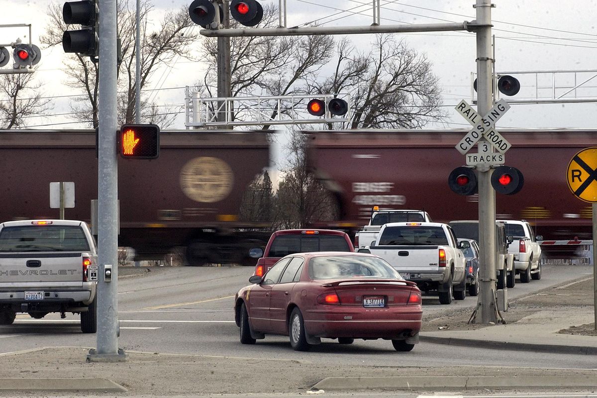 Southbound cars wait while a train passes at the intersection of Pines Road and Trent Avenue in Spokane Valley on March 21, 2006. The city of Spokane Valley is changing its approach to grant applications to improve chances that the crossing and another at-grade crossing at Barker Road near Trent will receive the millions in federal grant dollars needed for construction of an underpass and overpass. (Liz Kishimoto / The Spokesman-Review)