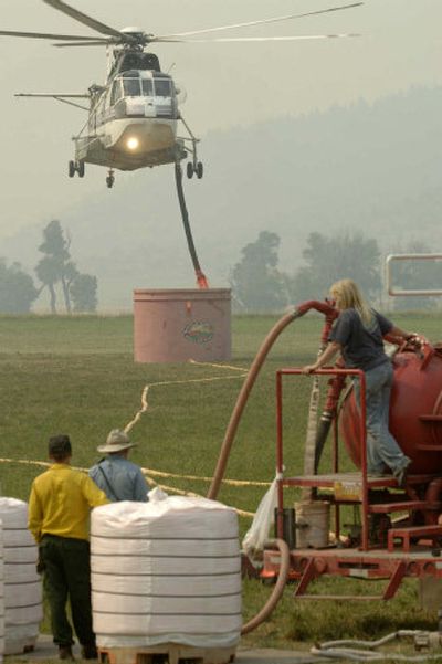 
A helicopter picks up a load of fire retardant from a mobile retardant base set up north of McLeod, Mont., on Tuesday. 
 (Associated Press / The Spokesman-Review)