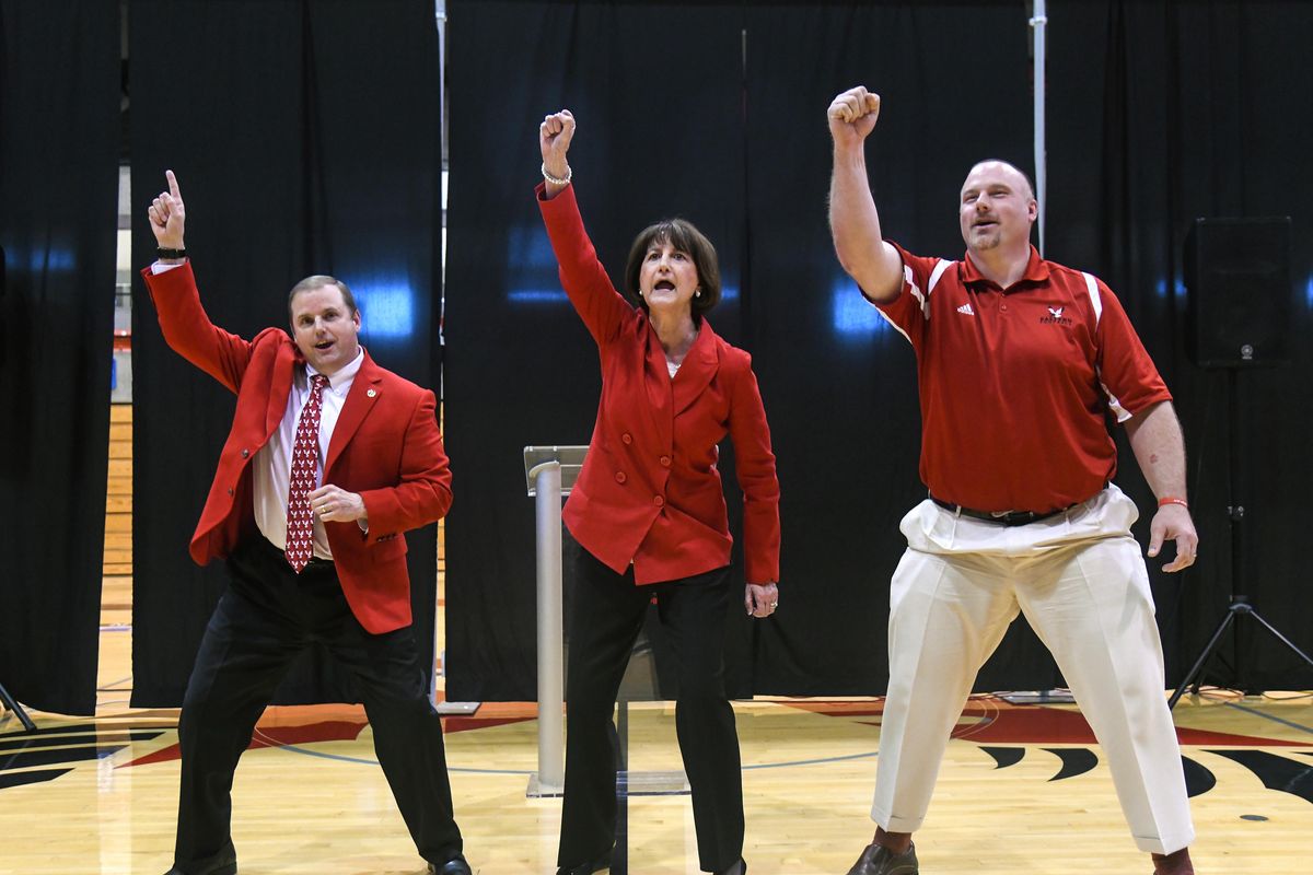 Scott Gordon, Provost and Search Committee Co-Chair, left, new Director of Athletics Lynn Hickey, center, and football coach Aaron Best close Hickey’s introduction ceremony with an EWU cheer, Wednesday, April 25, 2018, at Reese Court in Cheney, Wash. (Dan Pelle / The Spokesman-Review)