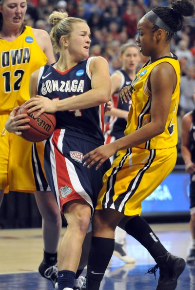 Gonzaga's Kelly Bowen, center, yanks a rebound away from Iowa's Kachine Alexander, right, and Morgan Johnson, left, on Saturday, March 19, 2011 at Gonzaga University in the opening round of the NCAA tournament.  The Zags won 86-92. (Jesse Tinsley / The Spokesman-Review)