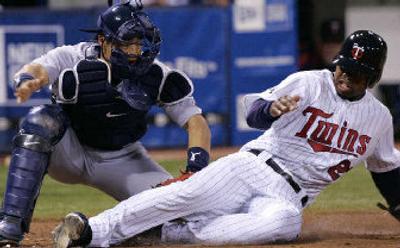 
Minnesota's Shannon Stewart slides into Kenji Johjima's tag. 
 (Associated Press / The Spokesman-Review)