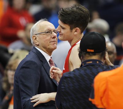 Syracuse head coach Jim Boeheim, left, congratulates his son, Cornell's Jimmy Boeheim, right, at the end of an NCAA college basketball game in Syracuse, N.Y., in Nov. 2017. Jimmy Boeheim is transferring to Syracuse to play for his father and with his younger brother after three seasons at Cornell. Coach Jim Boeheim's oldest son made the announcement Friday, April 16, 2021, on Instagram.  (Associated Press)