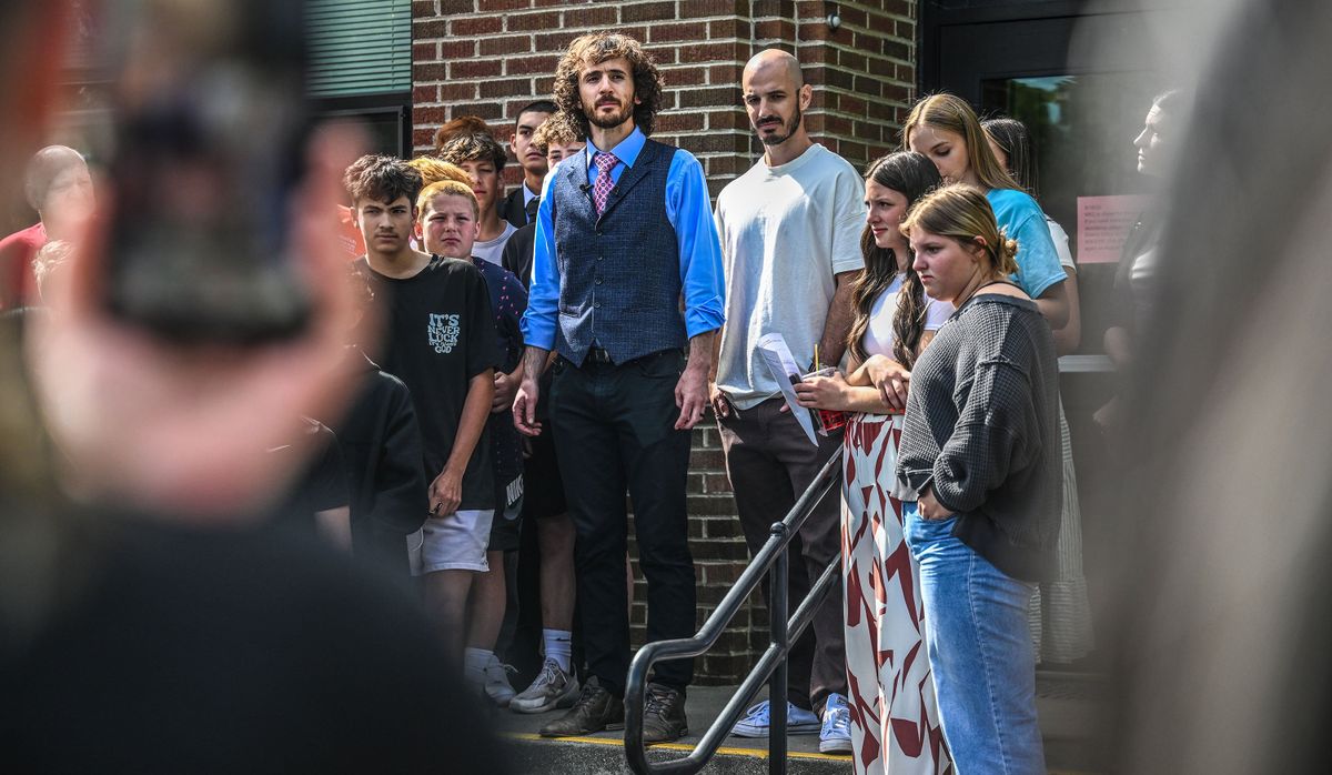 Former West Valley teacher Matthew Mastronardi , center left, and his brother Andrew Mastronardi address the crowd of supporters after the West Valley School Board voted to not renew his contract on Wednesday. (Kathy Plonka/The Spokesman-Review)