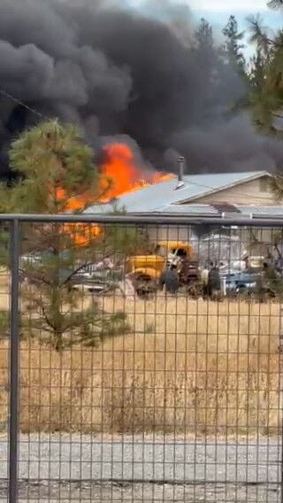 A photo captured by a neighbor shows a house – where two people were shot and killed two weeks ago – on fire on Monday afternoon.  (Chad Aubertin)