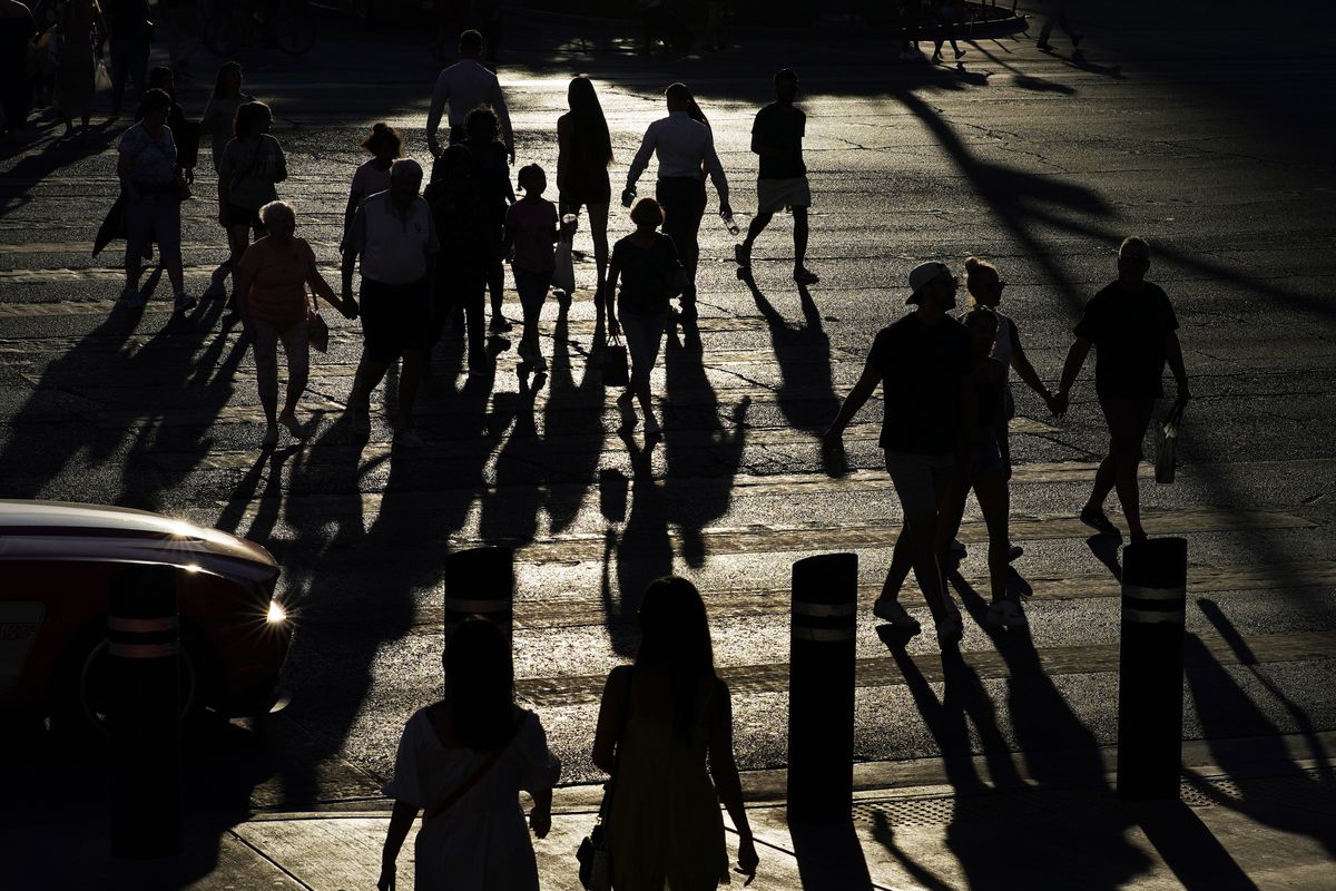 People cross Las Vegas Boulevard, Friday, July 2, 2021, in Las Vegas. Tourists are streaming into the city again, and gambling revenue has hit an all-time high. But that progress is threatened: Nevada this week saw the highest rate of new COVID-19 cases in the country.  (John Locher)