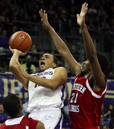Washington’s Andrew Andrews eludes Northern Illinois’ Darrell Bowie on his way to the basket on Saturday in Seattle. (Associated Press)