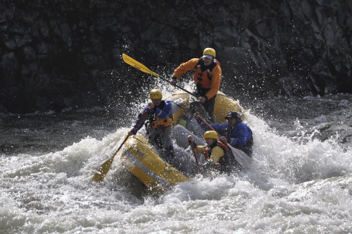 A raft of Peak 7 Adventures paddlers busts through the first big rapid entering the Bowl and Pitcher Area above the Riverside State Park suspension bridge with river flows around 16,000 cfs on March 13, 2016.   (Rich Landers)
