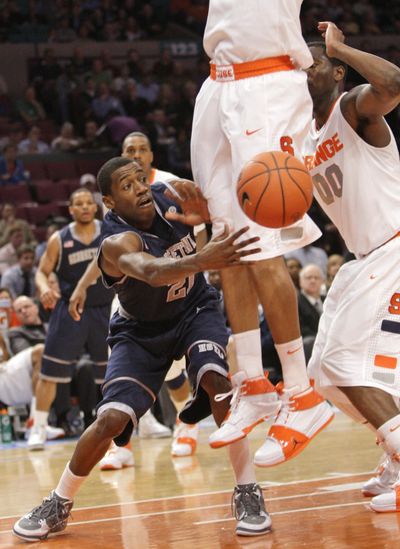 Georgetown’s Jason Clark passes around two Syracuse players during the Hoyas’ 91-84 Big East Tournament quarterfinal win.  (Associated Press)