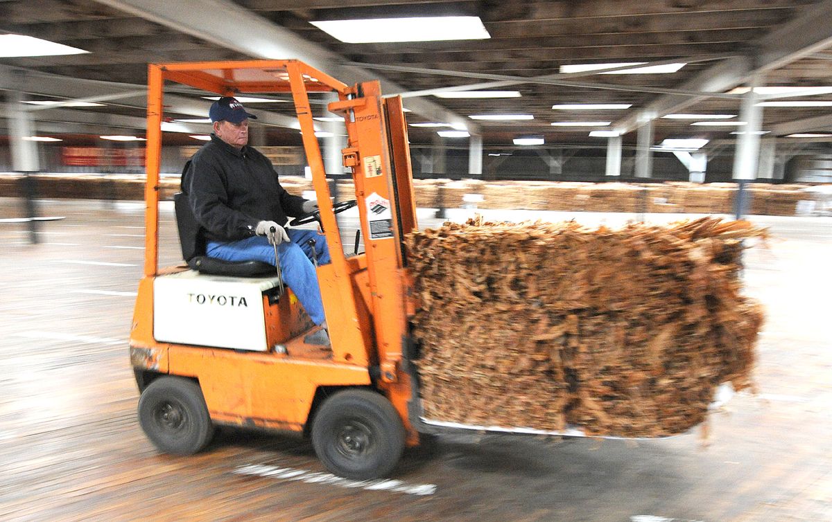 A floor manager helps unload tobacco at the Farmer’s Tobacco Warehouse in Kentucky.Associated Press photos (Associated Press photos / The Spokesman-Review)