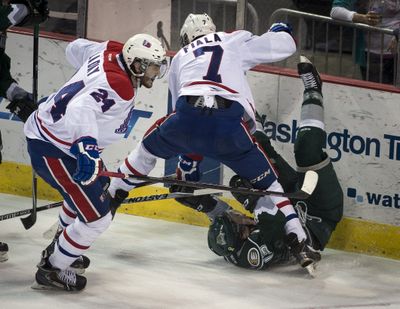 Spokane defenseman Evan Fiala checks Everett’s Remi Laurencelle into the boards. (Colin Mulvany)