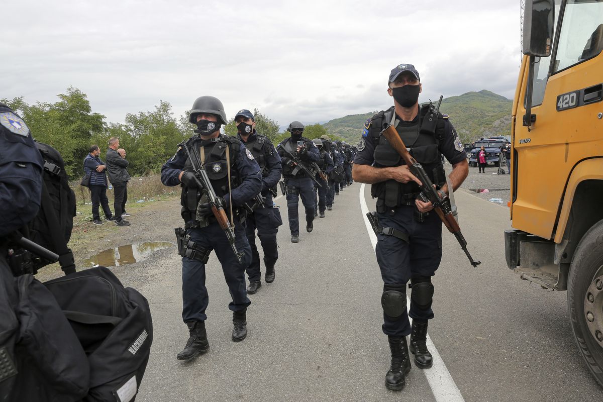 Kosovo police officers walk to replace their colleagues near the northern Kosovo border crossing of Jarinje on Tuesday, Sept. 21, 2021. Tensions soared Monday when Kosovo special police with armored vehicles were sent to the border to impose a rule on temporarily replacing Serb license plates from cars while they drive in Kosovo.  (Visar Kryeziu)