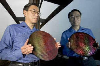 
Sunlin Chou, senior vice president and general manager of Intel's Technology & Manufacturing Group, holds a silicon wafer used to make Intel desktop processors.  
 (Associated Press / The Spokesman-Review)
