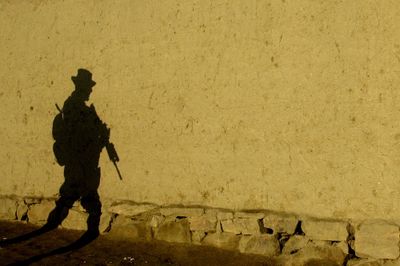 The shadow of a U.S. soldier from the Oklahoma Army National Guard is cast on a wall during a foot patrol at dawn in Hudkhell village on the outskirts of Kabul, Afghanistan.  (File Associated Press / The Spokesman-Review)