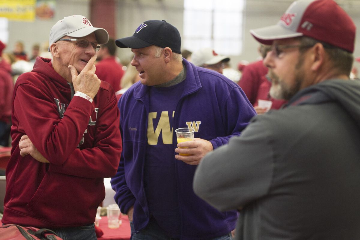 Keith Claassen, left, and friend of 15 years Mark Simpson, center, chat about the game before the start of the 2016 Apple Cup on Friday, Nov 25, 2016, at WSU