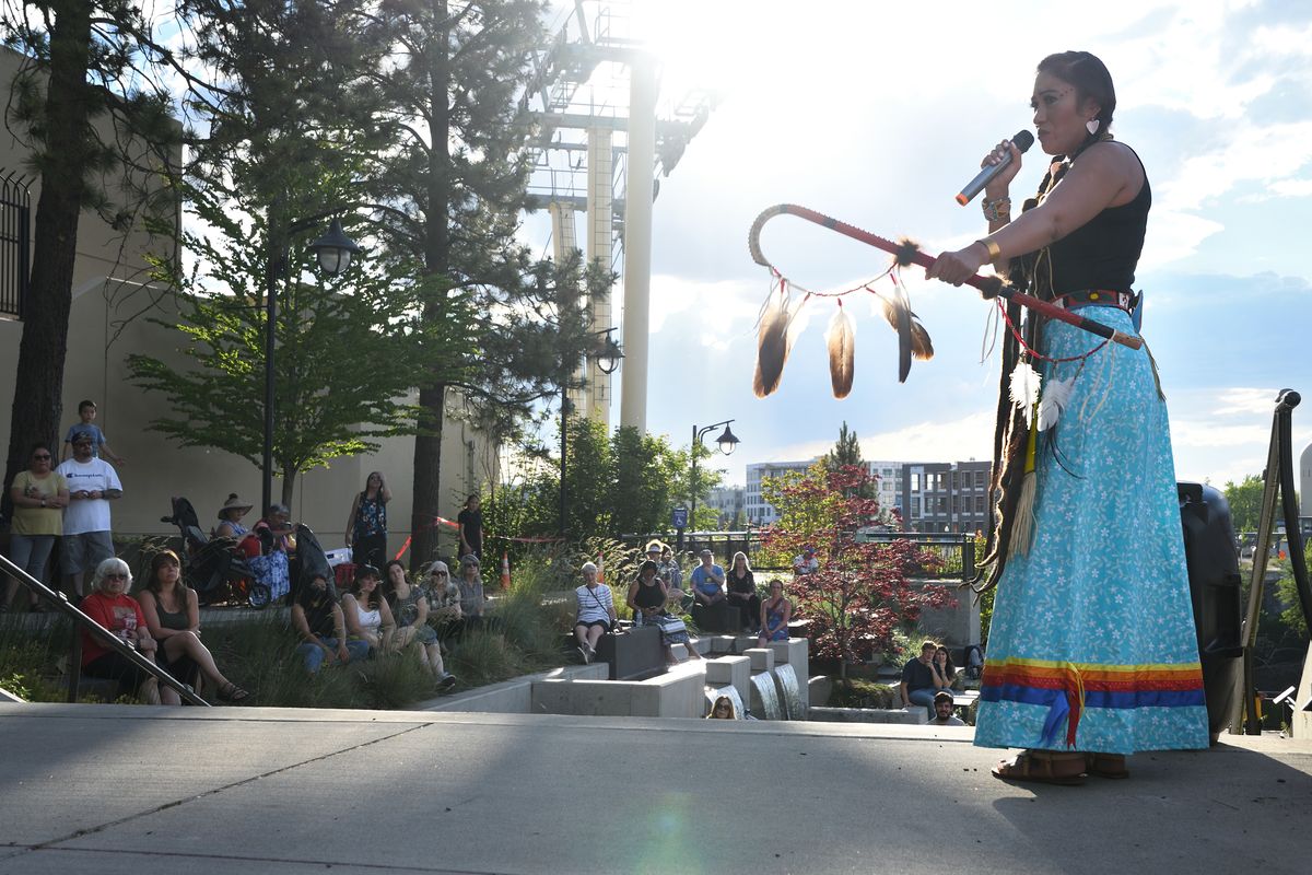 Shawnee Bearcub talks to the crowd Sunday evening at a vigil held at The Gathering Place near Spokane Falls. The vigil was organized after the Tk’emlúps te Secwe̓pemc First Nation in British Columbia announced last month it had found the remains of 215 children in a mass grave at the Kamloops Indian Residential School.   (Colin Tiernan/THE SPOKESMAN-REVIEW)