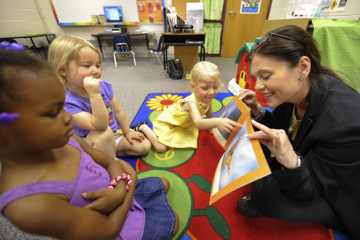 Shelley Redinger reads to preschool students May 2 at Riverview Elementary in Spotsylvania County, Va., where she is the schools superintendent. From left are Moriah Ward, 4; Chelsea Crabtree, 4; and Kayleigh McFarren, 3. (CLEMENT BRITT)