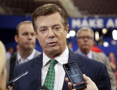 In this July 17, 2016  photo, then-Trump Campaign Chairman Paul Manafort talks to reporters on the floor of the Republican National Convention at Quicken Loans Arena in Cleveland as Rick Gates listens at back left. (Matt Rourke / Associated Press)