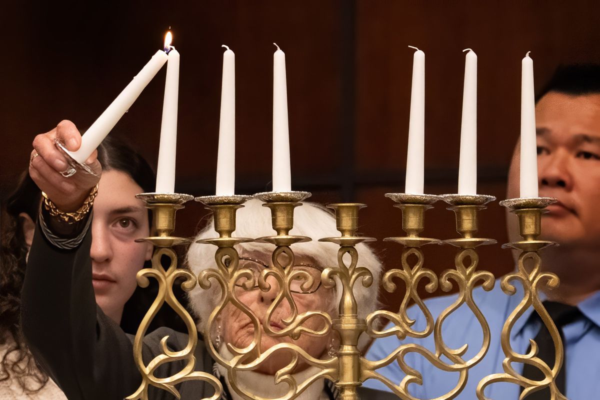 During the Spokane Community Observance of the Holocaust at Temple Beth Shalom Wednesday night, Holocaust survivor Carla Peperzak lights the first of six candles in memory of the 6 million jews who were killed by Nazi Germany during World War II.  (COLIN MULVANY/THE SPOKESMAN-REVI)