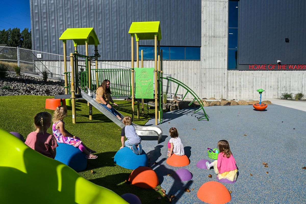 Almira School pre-K teacher Amanda Goodwin takes a ride down the slide during recess, Tuesday, Sept 5, 2023. The community has a new new school after a fire destroyed the old building on Oct. 12, 2021.  (DAN PELLE/THE SPOKESMAN-REVIEW)