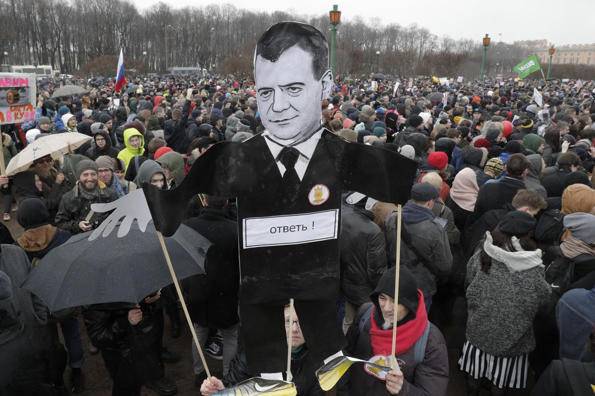 Protesters hold a cardboard cutout poster depicting Russian Prime Minister Dmitry Medvedev at Marsivo Field in St.Petersburg, Russia, Sunday. Thousands of people crowded in St.Petersburg on Sunday for an unsanctioned protest against the Russian government, the biggest gathering in a wave of nationwide protests that were the most extensive show of defiance in years. (Dmitri Lovetsky / Associated Press)