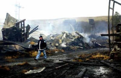 
Spokane County Fire District 11 firefighter Chris Ramsey walks through the wreckage of the Seeds Inc. storage building in Rockford on Friday morning. A Thursday evening fire reduced it to rubble. No one was injured in the blaze. 
 (Holly Pickett / The Spokesman-Review)