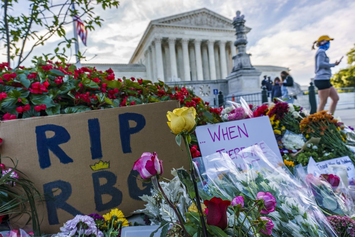 People gather at the Supreme Court on the morning after the death of Justice Ruth Bader Ginsburg, 87, Saturday, Sept. 19, 2020 in Washington.  (J. Scott Applewhite)
