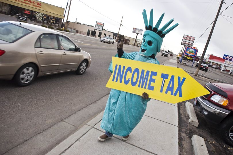 Phil Mangeac of Nampa, Idaho waves to motorists as they pass by a tax preparation location on Monday, April 12, 2010 in Nampa. (Charlie Litchfield / Idaho Press-tribune)