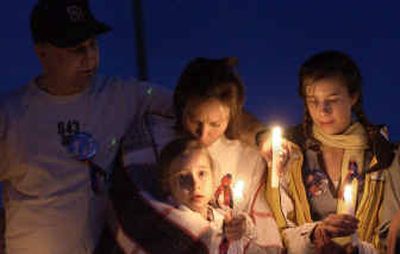 
Mandy Smidt, 8, is comforted by her mom, Sherene, at a candlelight vigil for the Groene family with her father, Jim, and sister, Kelsey, 14, at the Kootenai County Fairgrounds on Tuesday. 
 (Tom Davenport/ / The Spokesman-Review)