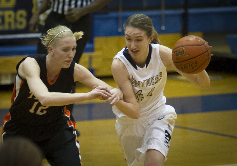 Lewis and Clark's Emma Keenan (12) makes contact with Mead's Sue Winger (44) as she dribbles the ball downcourt during the first half of a girl's GSL high school basketball game, Tuesday, Feb. 11, 2014, at the Mead High School. (Colin Mulvany / The Spokesman-Review)
