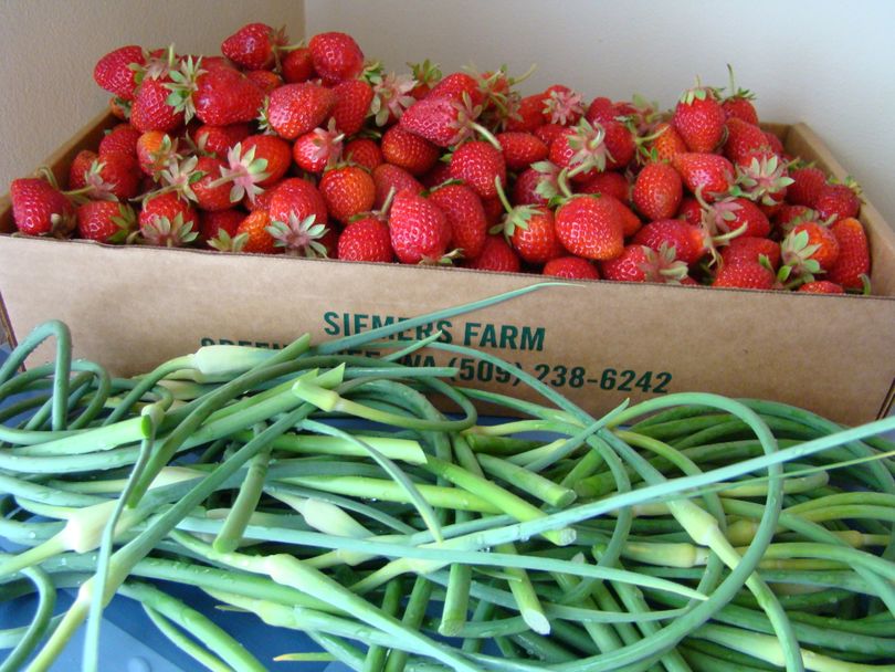 A flat of strawberries from Siemer's Farm on Greenbluff and garlic scapes from the Spokane Farmers' Market. (Maggie Bullock)