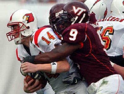 
Louisville QB Hunter Cantwell is tackled by Virginia Tech's Vince Hall. 
 (Associated Press / The Spokesman-Review)
