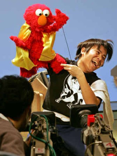 
Kenta Matsumoto, a Muppet operator, handles Elmo, a popular Sesame Street character, during a TV show filming at a Tokyo studio last month.  
 (Associated Press / The Spokesman-Review)