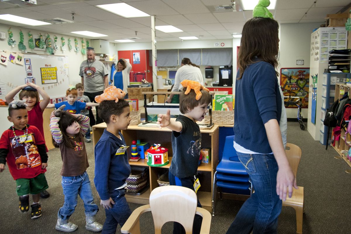 Head Start students at Holmes Elementary School follow their teacher, Lisa Forsyth, in a classroom parade Tuesday with beanbag animals atop their heads.