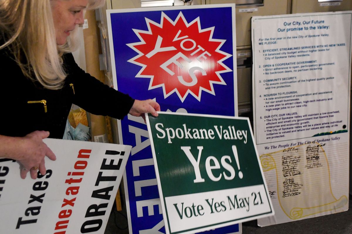 Spokane Valley Heritage Museum executive director Jayne Singleton looks through 20-year-old signs from the anniversary of the existence of the City of Spokane Valley on March 15.  (Kathy Plonka/The Spokesman-Review)