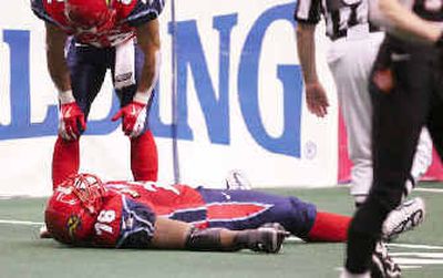Los Angeles Avengers player Al Lucas lies on the ground after being injured while trying to make a tackle on a first-quarter kickoff return against the New York Dragons on Sunday.
(Associated Press / The Spokesman-Review)