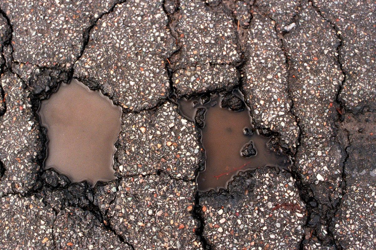 Cracks and potholes fill with water. (Spokesman-Review)