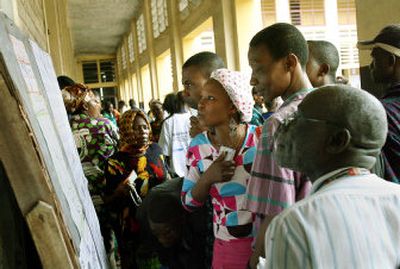 
Residents check for their names outside a polling station before voting in Kinshasa, Congo, on Sunday. 
 (Associated Press / The Spokesman-Review)