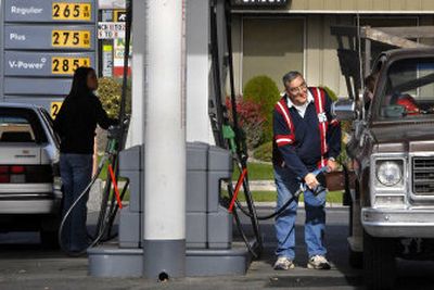 
Dick Volpe  fuels his truck while chatting with Tim Murphy at a gas station at Hamilton Street and Baldwin Avenue in Spokane on Tuesday. At left, Gonzaga University student Kathleen Yalung fuels her car. 
 (Dan Pelle / The Spokesman-Review)