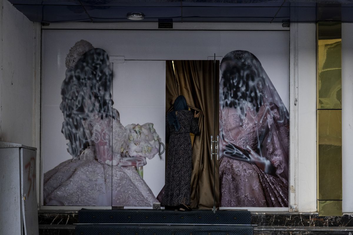 An Afghan woman enters a beauty salon in Kabul, Afghanistan, Saturday, Sept. 11, 2021. Since the Taliban gained control of Kabul, several images depicting women outside beauty salons have been removed or covered up.  (Bernat Armangue)
