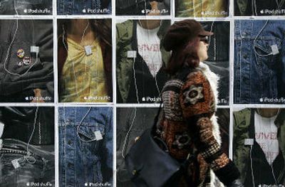 A woman walks past a wall of poster ads for the iPod shuffle outside the Apple store in San Francisco on Friday. Apple Computer Inc. cleared Chief Executive Steve Jobs and the rest of its current management of misconduct involving stock option grants, despite Jobs' awareness of favorable grant dates. 
 (Associated Press / The Spokesman-Review)