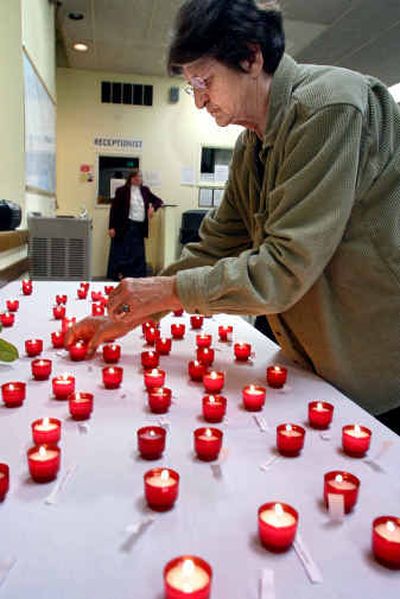 
Barbara Evans Cram lights a candle during a memorial for Seattle area homeless people who died last year. 
 (Associated Press / The Spokesman-Review)
