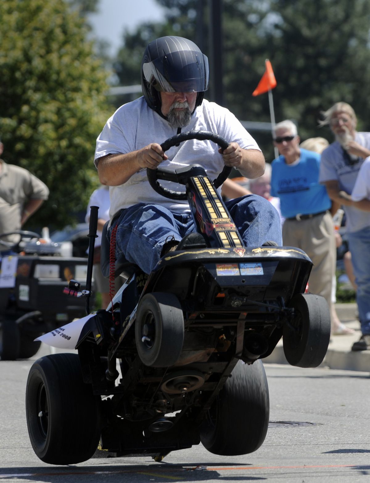 Curt Green holds on while his highly modified lawnmower pops a wheelie at the starting line of lawnmower races Saturday at Rathdrum Days. The races were part of a weekend of activities including weiner dog races, live music, food booths and a parade.  (Jesse Tinsley / The Spokesman-Review)